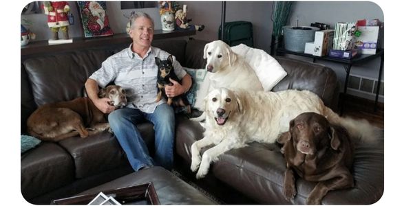 Owner of Muddy Puppy and all of his dogs on the sofa at home